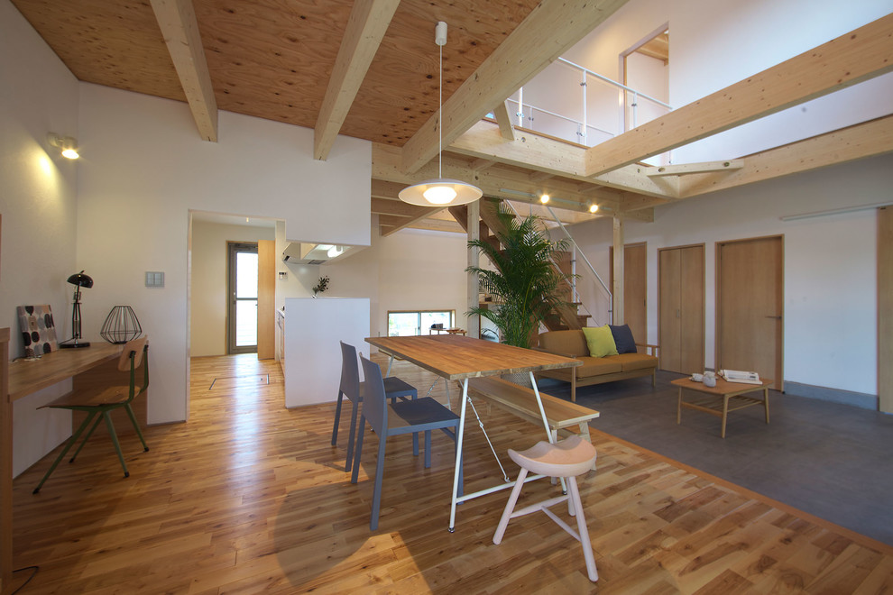 Imagen de comedor industrial abierto con paredes blancas, suelo de madera en tonos medios y suelo marrón
