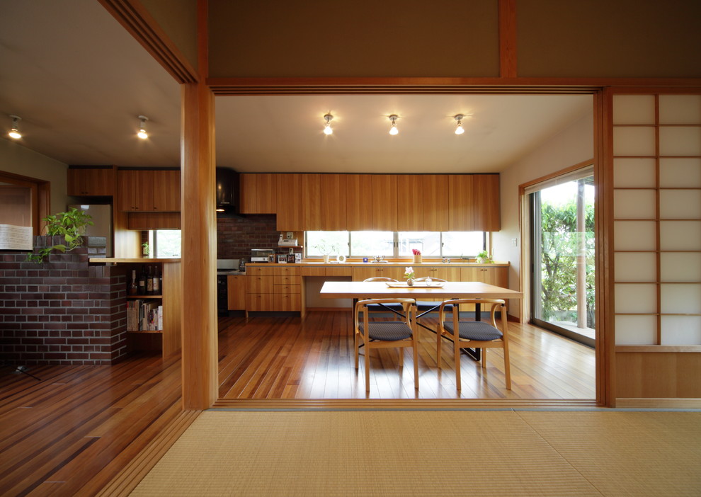 Cette image montre une salle à manger ouverte sur le salon design avec un sol en bois brun, un sol marron et un mur beige.