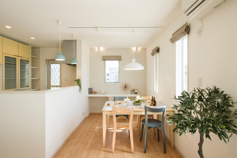 Стильный дизайн: маленькая гостиная-столовая в скандинавском стиле с белыми стенами, светлым паркетным полом и коричневым полом для на участке и в саду - последний тренд