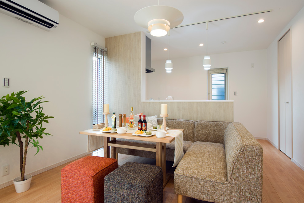 Foto di una piccola sala da pranzo scandinava con pareti bianche, parquet chiaro e pavimento marrone
