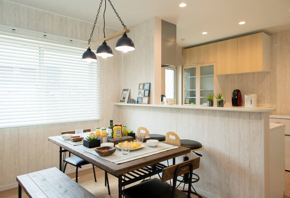 Immagine di una piccola sala da pranzo aperta verso il soggiorno stile marino con pareti beige, parquet chiaro e pavimento beige