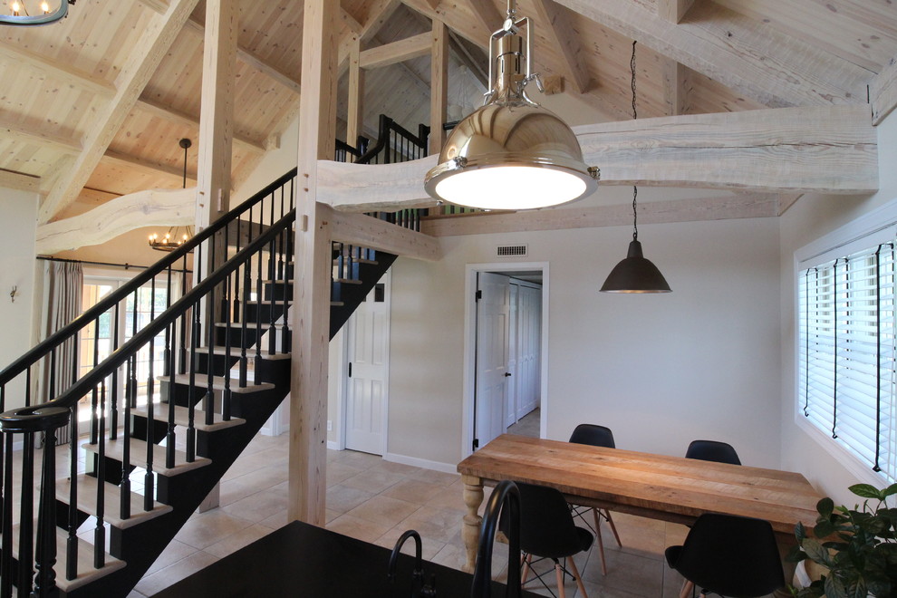 Foto di una sala da pranzo aperta verso il soggiorno nordica con pareti beige e pavimento in terracotta