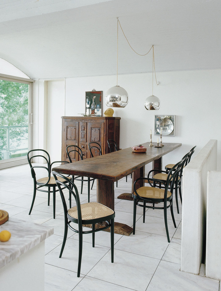 Idee per una sala da pranzo aperta verso la cucina boho chic con pareti bianche e pavimento bianco