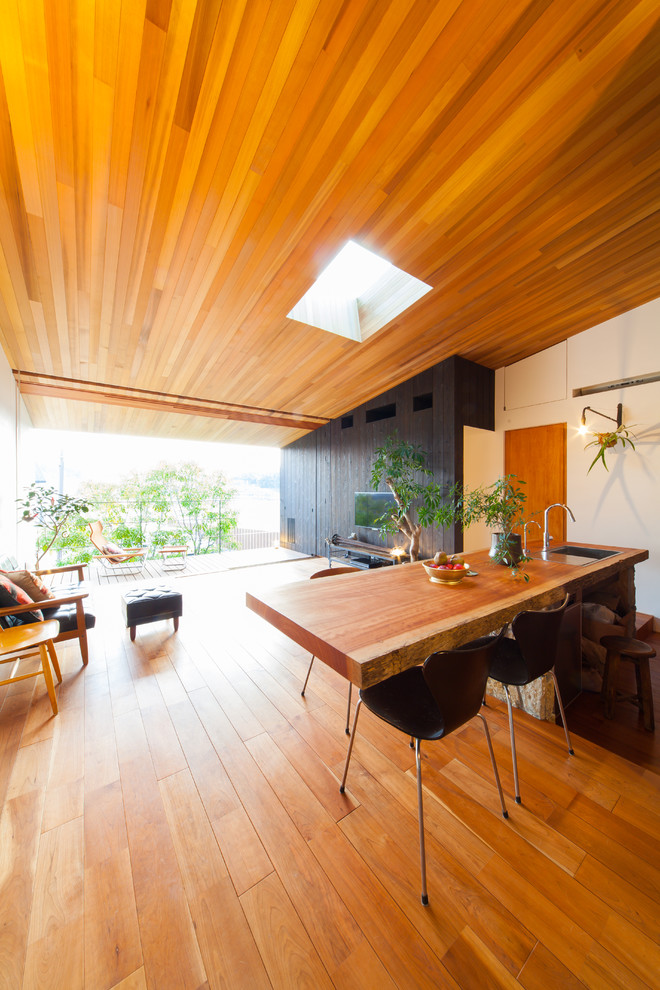 Idée de décoration pour une salle à manger asiatique avec un sol en bois brun.