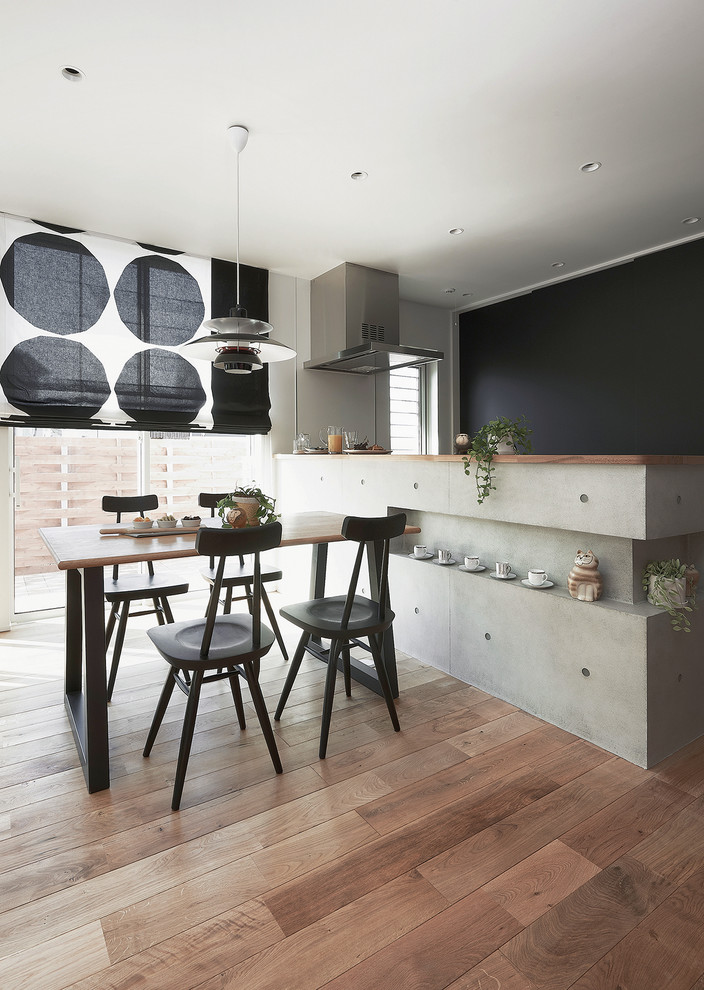 Exemple d'une salle à manger ouverte sur la cuisine asiatique avec un mur noir, parquet clair et aucune cheminée.