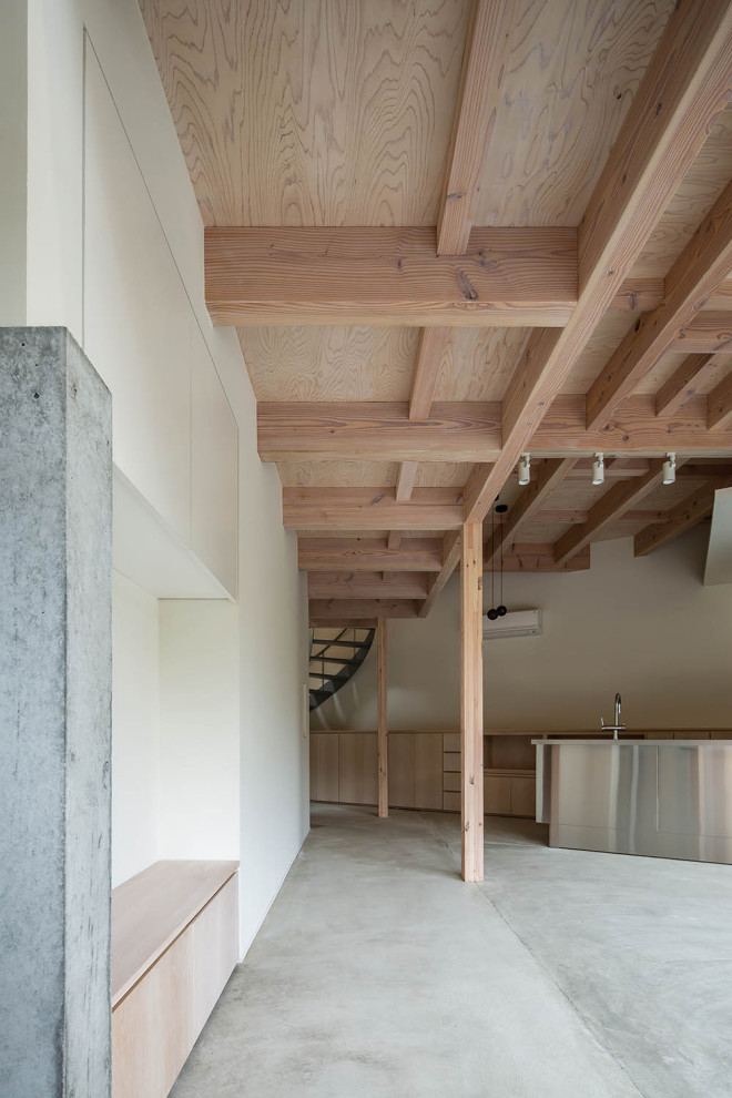 Small world-inspired open plan dining room in Nagoya with white walls, concrete flooring, a wood burning stove, a concrete fireplace surround, grey floors and exposed beams.
