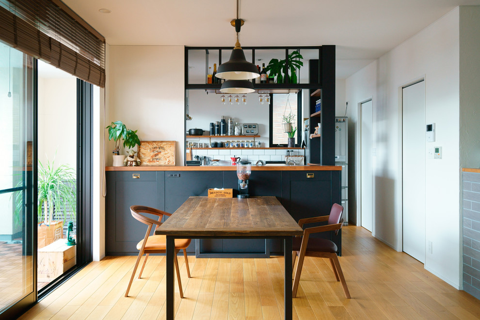 Inspiration pour une salle à manger ouverte sur le salon bohème avec un mur blanc, un sol en bois brun et un sol marron.