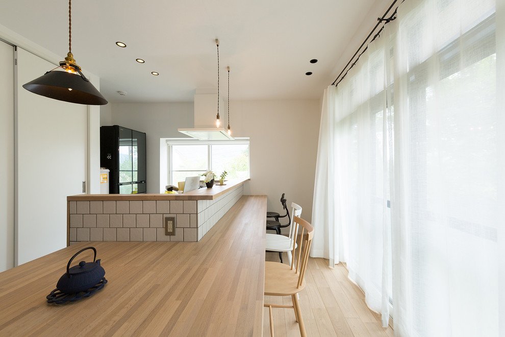 Foto di una sala da pranzo scandinava con pareti bianche, parquet chiaro e pavimento marrone