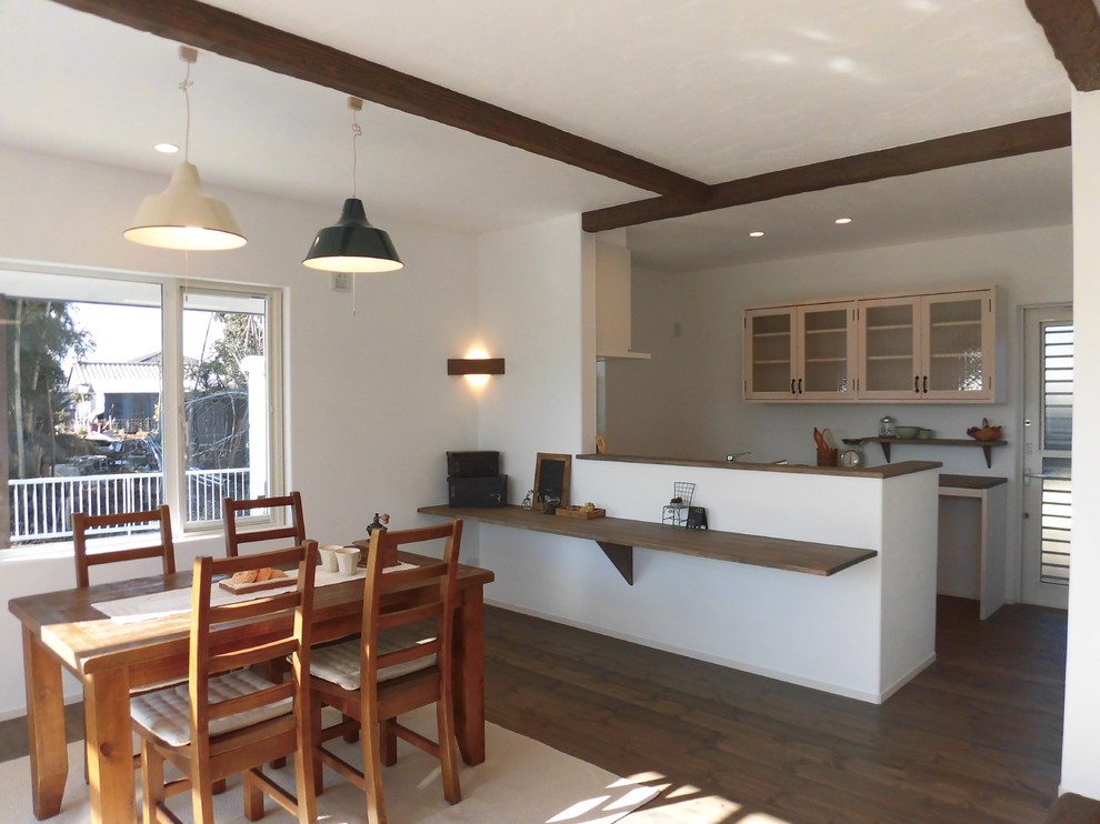 Imagen de comedor de estilo de casa de campo abierto con paredes blancas, suelo de madera en tonos medios y suelo marrón