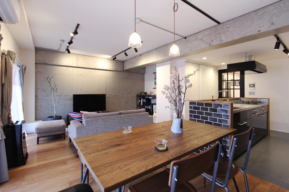 Cette image montre une salle à manger urbaine avec un mur gris, un sol en bois brun et un sol marron.