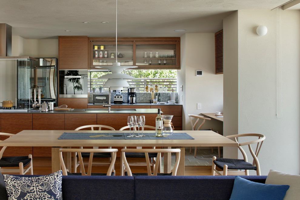 Пример оригинального дизайна: гостиная-столовая в современном стиле с белыми стенами и паркетным полом среднего тона
