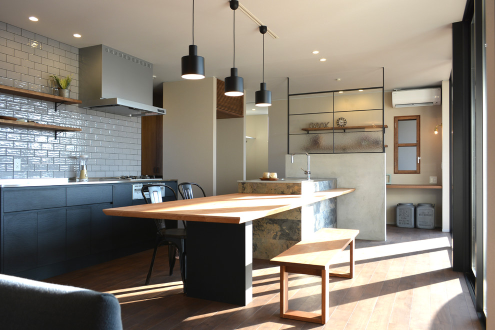 Idée de décoration pour une salle à manger ouverte sur le salon urbaine avec un mur blanc, un sol en bois brun et un sol marron.