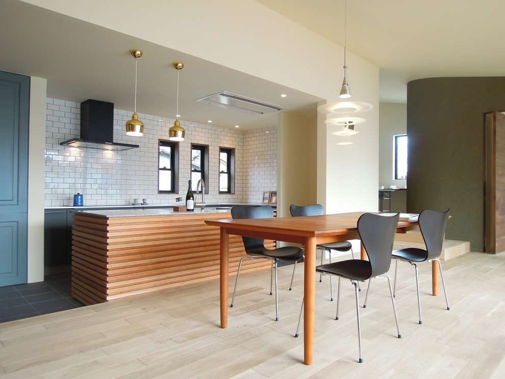 Idee per una sala da pranzo aperta verso la cucina design con pareti bianche e parquet chiaro