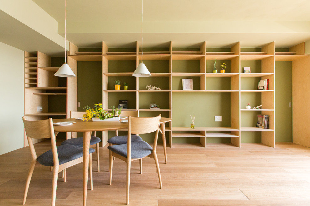 Skandinavisches Esszimmer mit grüner Wandfarbe, hellem Holzboden und braunem Boden in Sonstige
