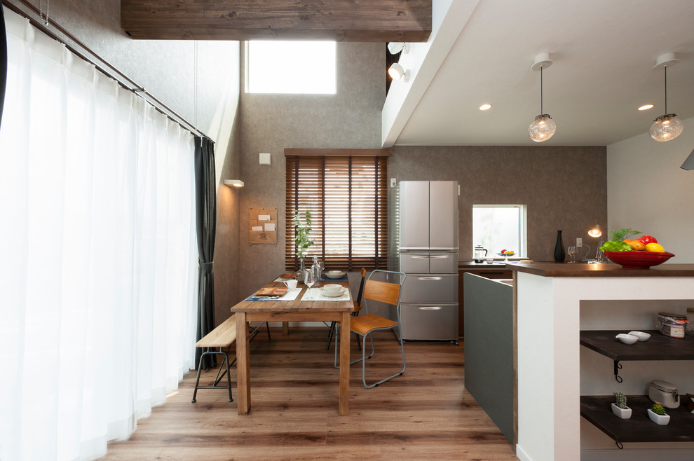 This is an example of a medium sized urban dining room in Other with grey walls, no fireplace and brown floors.