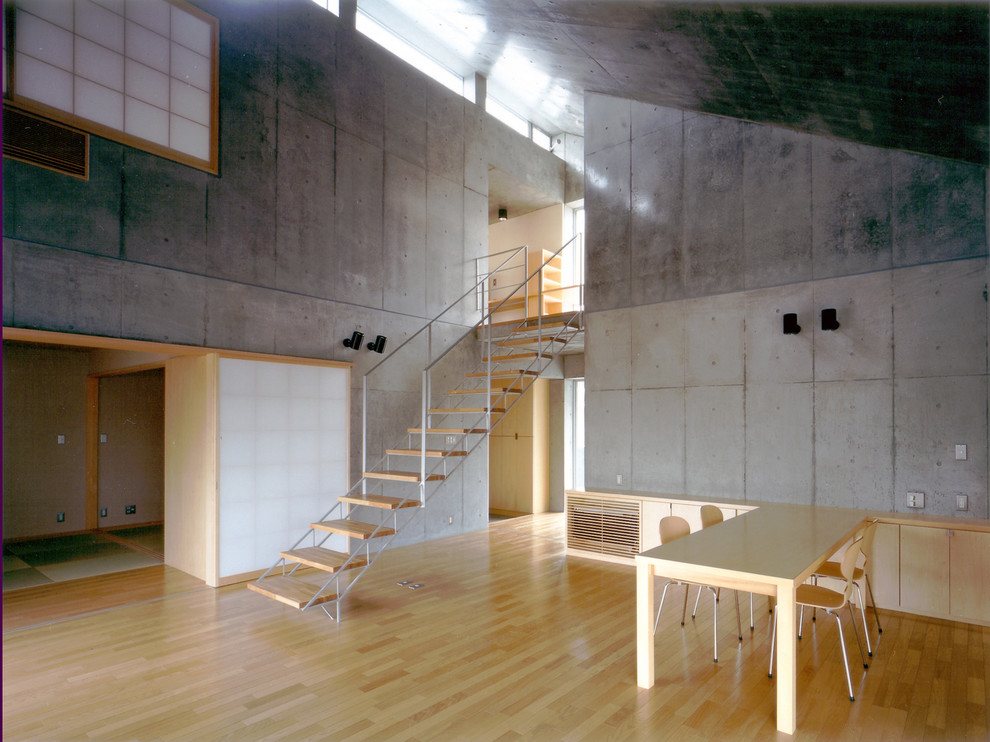 Foto på en industriell matplats med öppen planlösning, med grå väggar, mellanmörkt trägolv och brunt golv