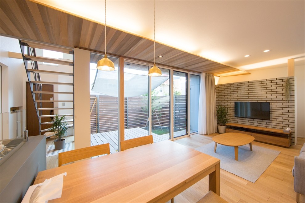 Modelo de comedor minimalista de tamaño medio abierto con paredes blancas, suelo de madera clara y suelo marrón