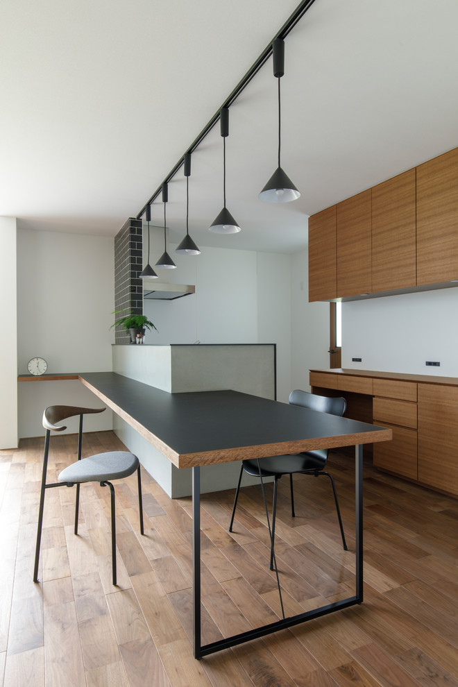 На фото: кухня-столовая в восточном стиле с серыми стенами, паркетным полом среднего тона и коричневым полом