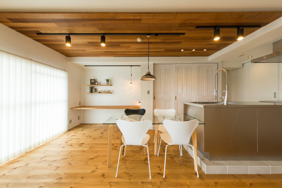 Idées déco pour une salle à manger scandinave avec un mur blanc, un sol en bois brun et un sol marron.