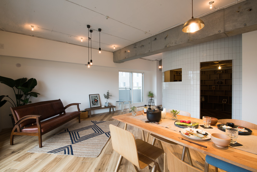 На фото: гостиная-столовая в стиле лофт с белыми стенами, паркетным полом среднего тона и коричневым полом