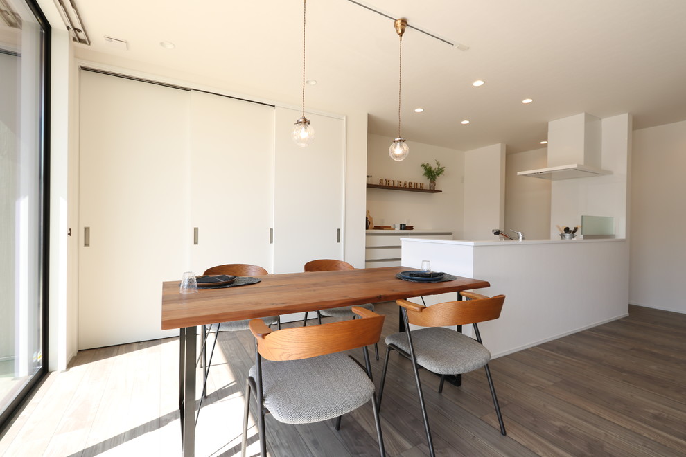 Ispirazione per una sala da pranzo minimalista con pavimento in legno verniciato e pavimento grigio