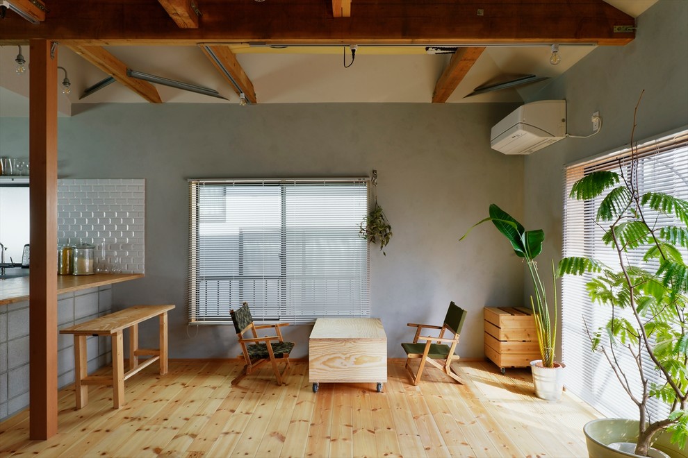Mid-sized urban light wood floor and beige floor great room photo with gray walls