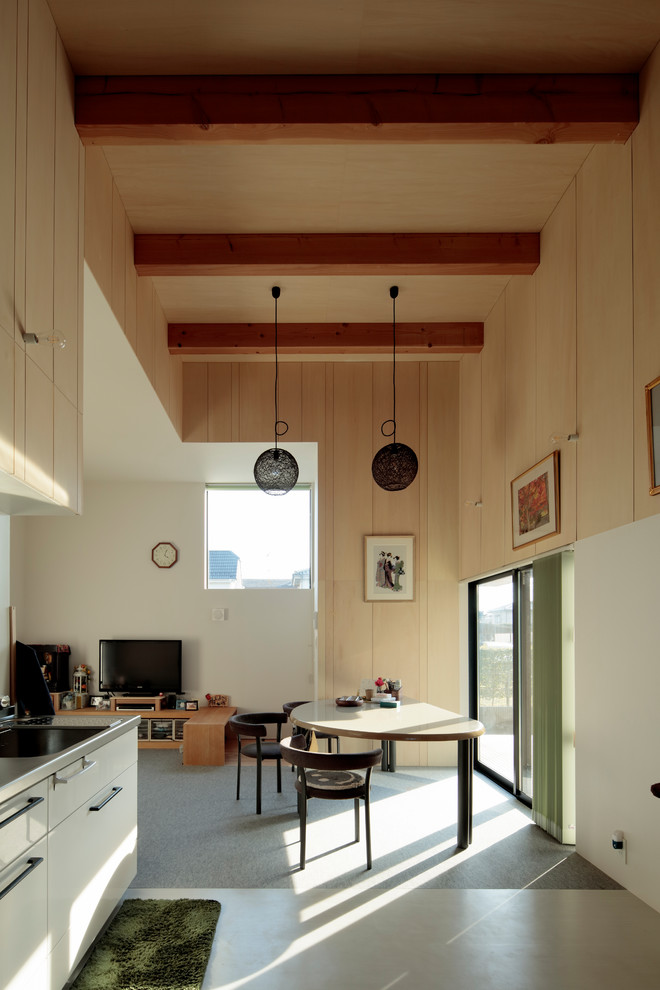 На фото: гостиная-столовая в стиле модернизм с бежевыми стенами, ковровым покрытием и серым полом