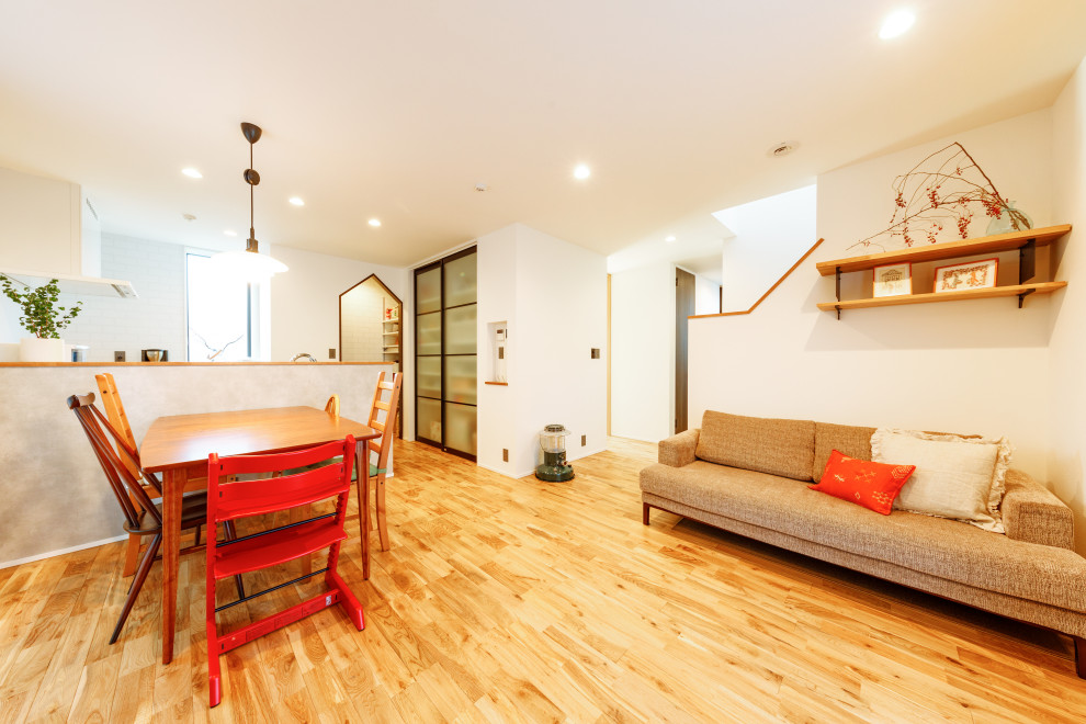 Foto di una sala da pranzo minimal con parquet chiaro e pavimento marrone