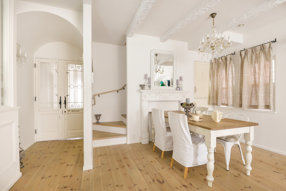 Réalisation d'une salle à manger tradition avec parquet clair, un mur blanc, une cheminée standard et un sol beige.