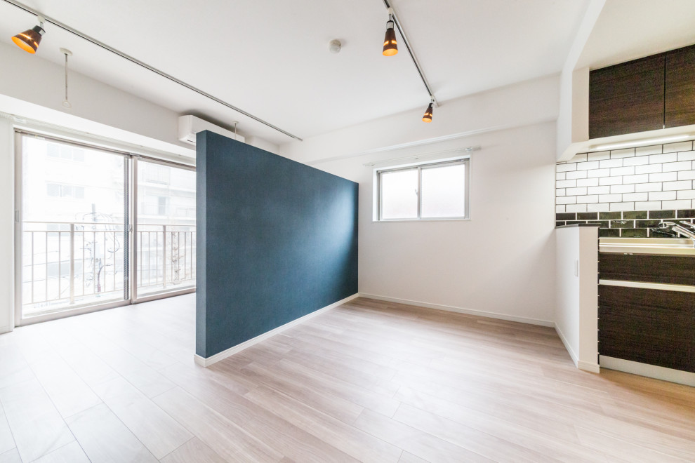 Immagine di una sala da pranzo aperta verso la cucina minimal di medie dimensioni con pareti bianche, pavimento in legno verniciato, nessun camino e pavimento marrone
