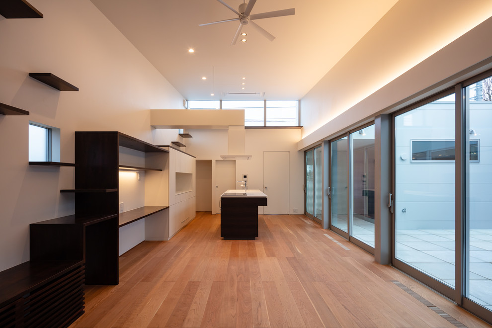 Diseño de comedor moderno abierto sin chimenea con paredes blancas, suelo de contrachapado y suelo marrón