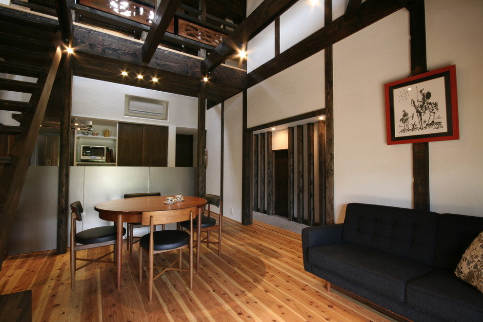 На фото: гостиная-столовая в восточном стиле с белыми стенами, паркетным полом среднего тона и коричневым полом с