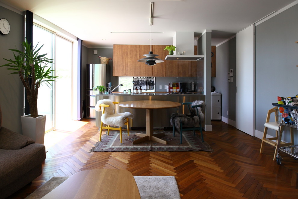 Esempio di una sala da pranzo contemporanea con pareti grigie, pavimento in legno massello medio e pavimento marrone
