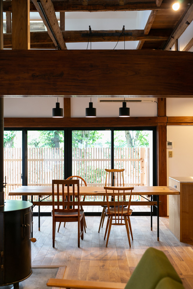 Inspiration för mellanstora moderna matplatser med öppen planlösning, med vita väggar, mellanmörkt trägolv, en öppen vedspis, en spiselkrans i betong och beiget golv