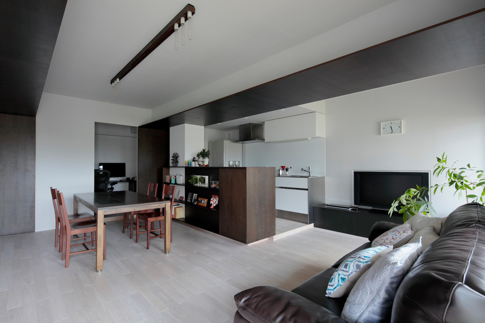 Ispirazione per una sala da pranzo aperta verso il soggiorno minimalista con pareti beige, pavimento in compensato e pavimento beige