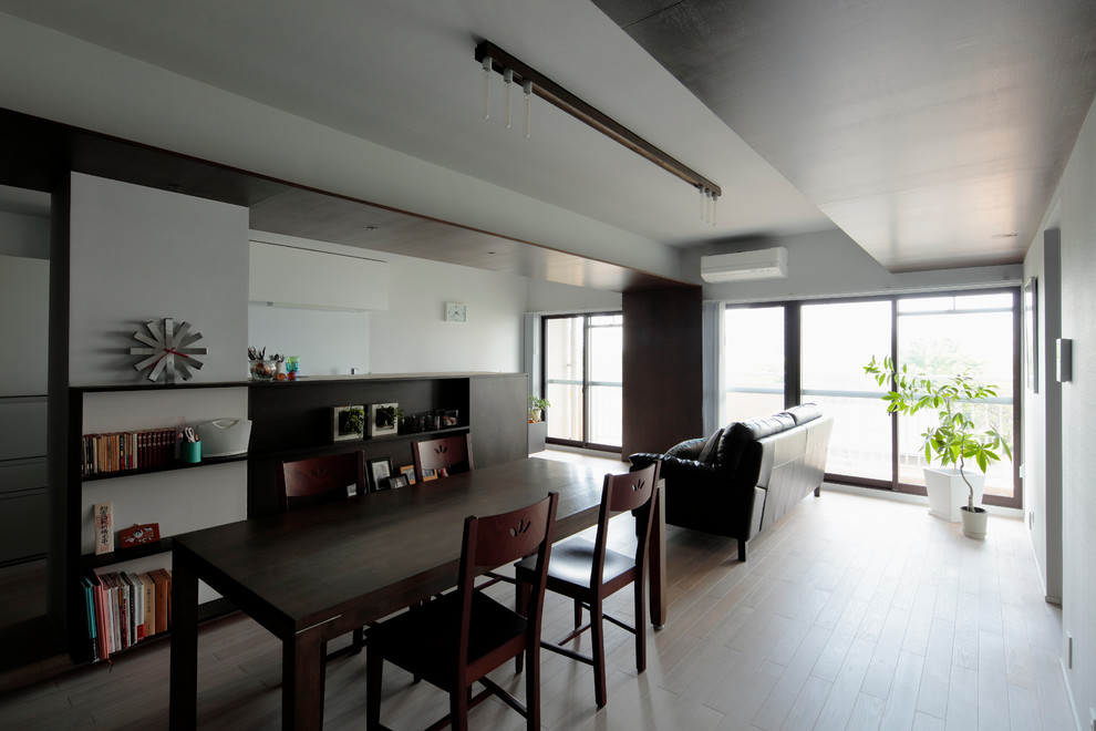 Offenes Modernes Esszimmer mit weißer Wandfarbe, Sperrholzboden und beigem Boden in Tokio