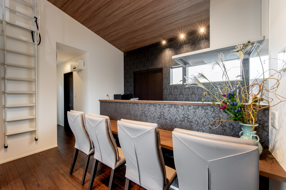 Aménagement d'une petite salle à manger ouverte sur la cuisine avec un mur noir, parquet foncé, un plafond en papier peint et du papier peint.