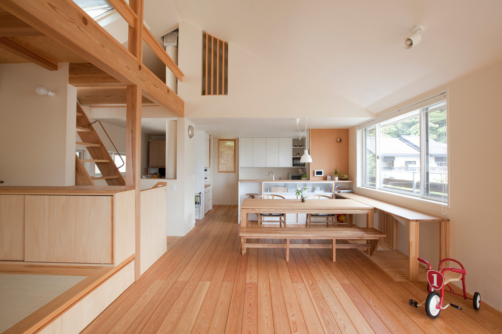 Great room - zen medium tone wood floor and brown floor great room idea in Yokohama with white walls