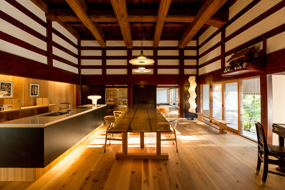 Réalisation d'une salle à manger ouverte sur le salon asiatique avec un mur beige, un sol en bois brun et un sol marron.