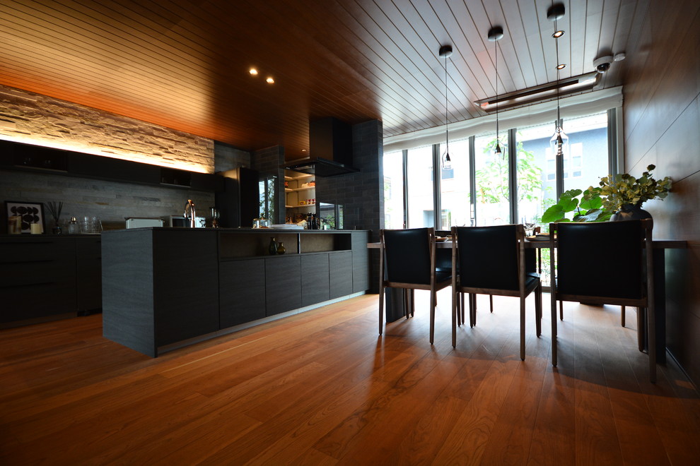 Cette photo montre une salle à manger ouverte sur le salon moderne avec un mur marron, un sol en contreplaqué, aucune cheminée et un sol rose.