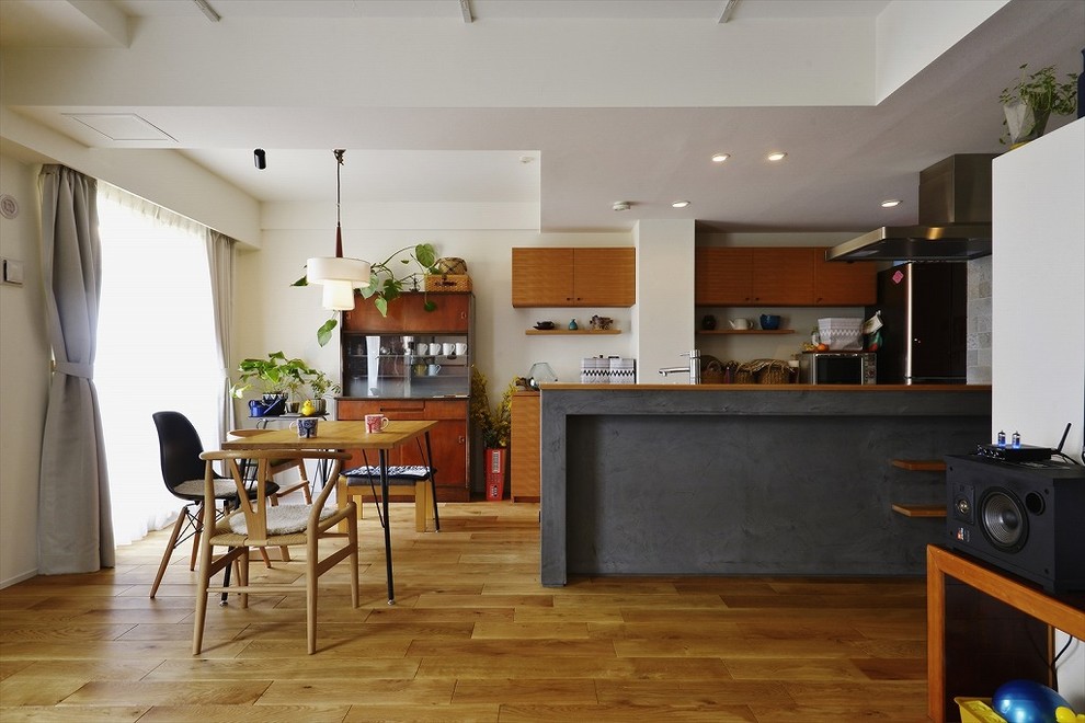 Idées déco pour une salle à manger ouverte sur le salon contemporaine avec un mur blanc, un sol en bois brun et un sol marron.