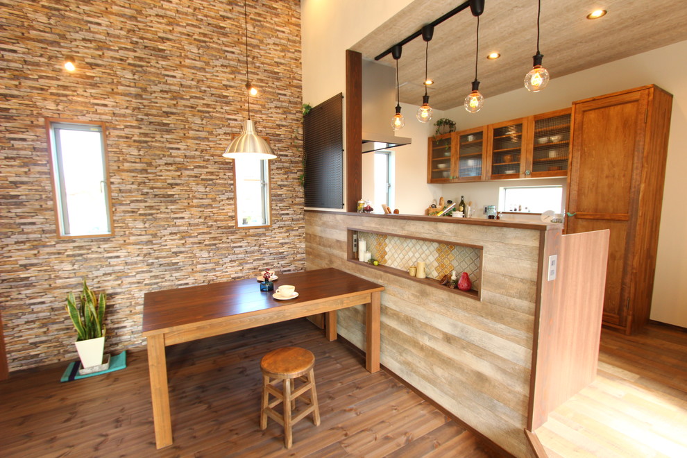 Cette photo montre une salle à manger industrielle avec un mur marron, parquet foncé et un sol marron.