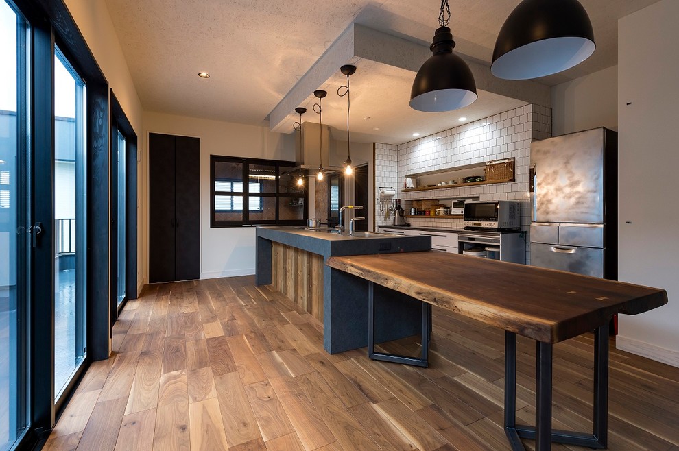 Industrial dining room in Other with medium hardwood flooring, brown floors and white walls.