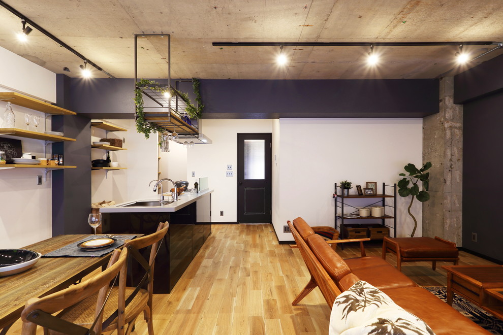 Foto di una grande sala da pranzo aperta verso il soggiorno industriale con pavimento in legno massello medio