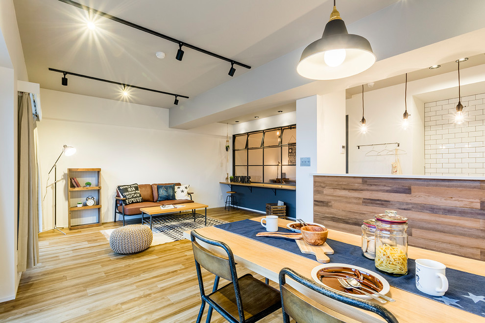 Design ideas for an urban open plan dining room in Tokyo with white walls, medium hardwood flooring, brown floors and feature lighting.