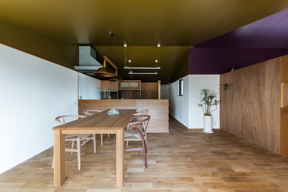 Idee per un'ampia sala da pranzo contemporanea con pareti bianche, pavimento in legno massello medio, nessun camino e pavimento marrone