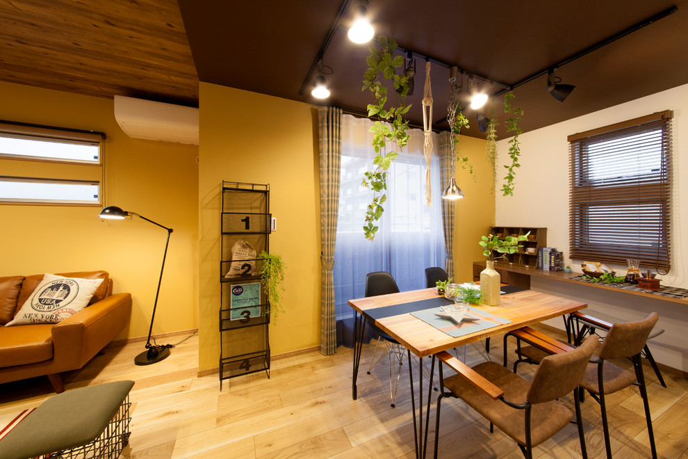 На фото: маленькая гостиная-столовая в стиле лофт с желтыми стенами, паркетным полом среднего тона и коричневым полом для на участке и в саду с