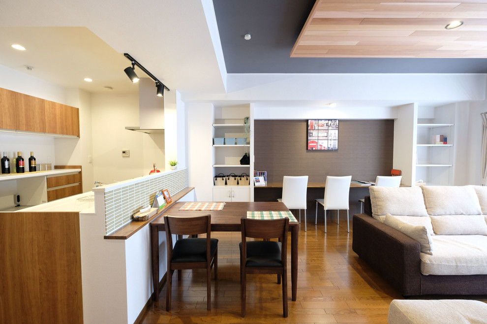 Ispirazione per una grande sala da pranzo aperta verso il soggiorno minimalista con pareti marroni, pavimento in compensato, nessun camino e pavimento marrone