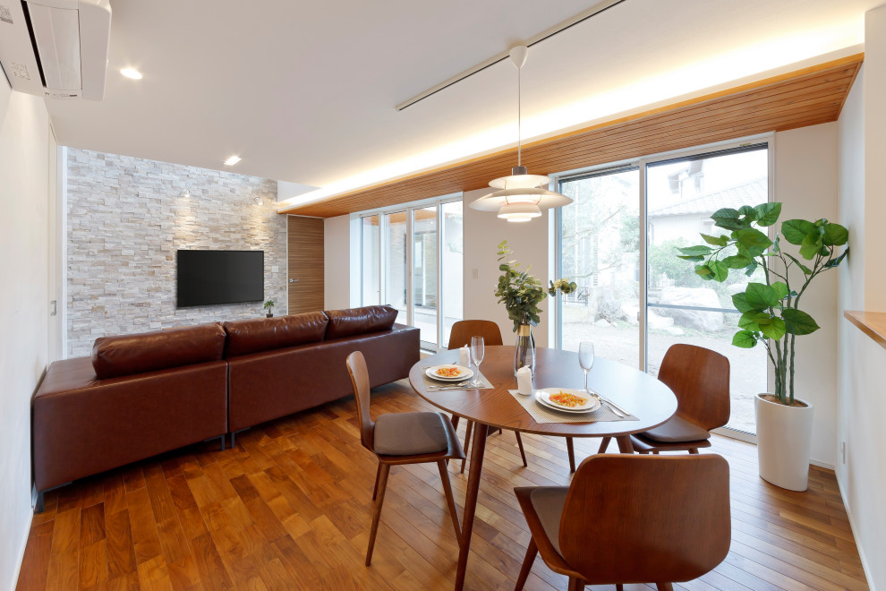 Cette photo montre une salle à manger ouverte sur le salon avec un mur blanc, un sol en bois brun, un sol marron, un plafond en papier peint et du lambris de bois.