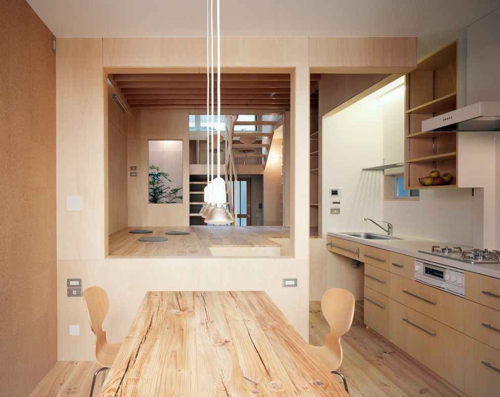 Imagen de comedor de cocina minimalista pequeño sin chimenea con paredes beige, suelo de madera clara, suelo beige y madera